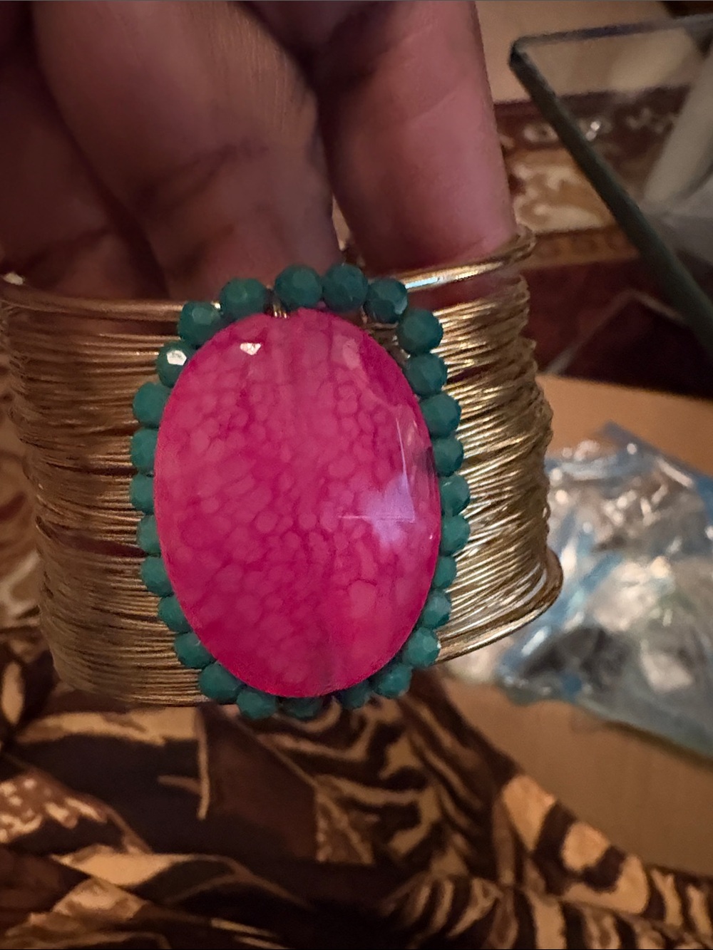Goldtone bracelet with magenta colored oval piece with small faceted beads